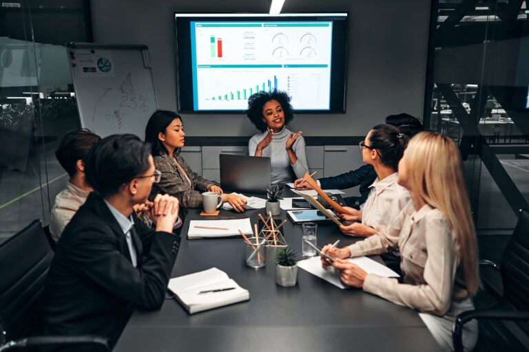 Young confident successful business people discuss and analyze work, statistics, plans, startup in a meeting room. Teamwork. Presentation